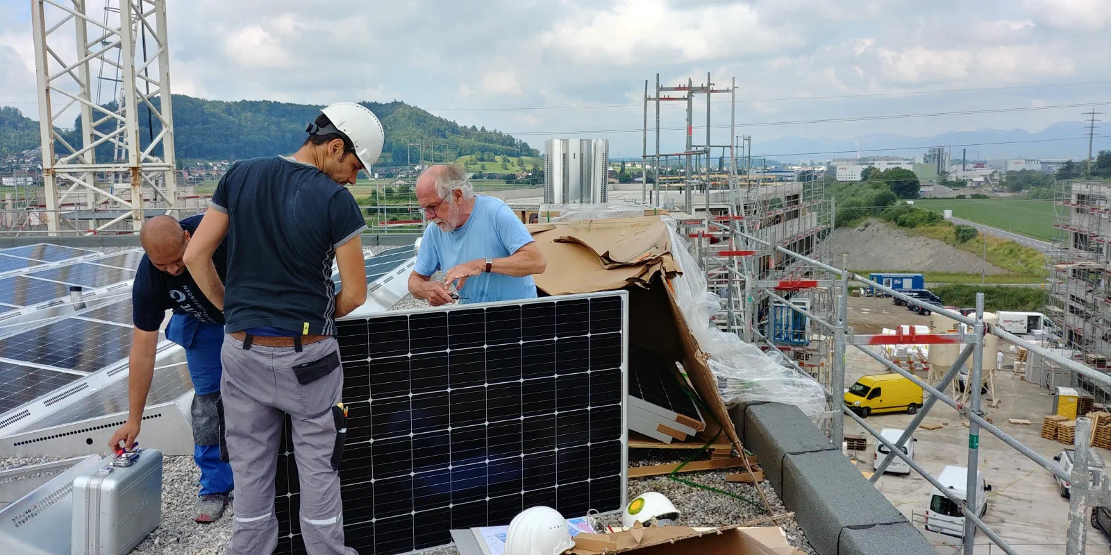 Monteure setzen ein Solarmodul auf dem Dach von Haus B2 ein