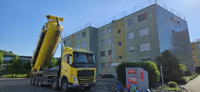 Gelber Silolastwagen vor einem der Mehrfamilienhäuser an der Fünflindenstrasse