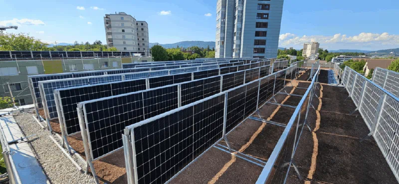 Reihen vertikal aufgeständerter Solarmodule auf dem Dach mit Substrat für die Begrünung