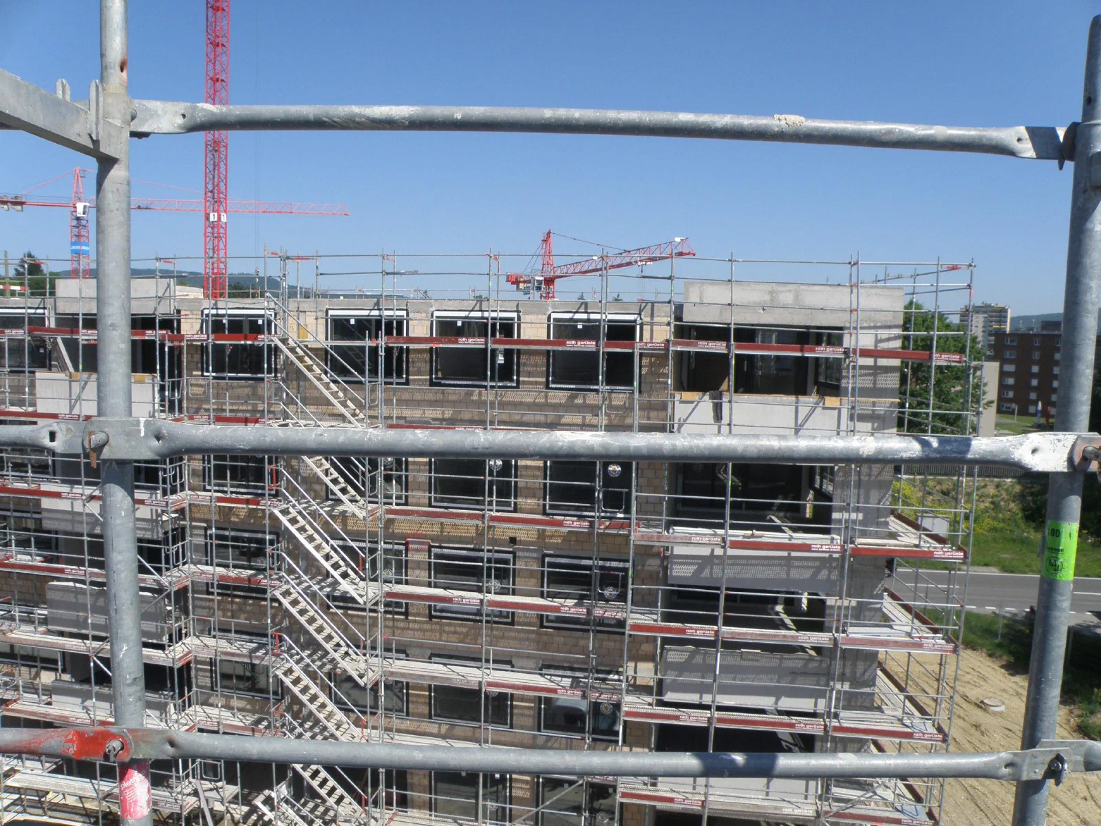 Haus B1 im Rohbau hinter einem Baugerüst