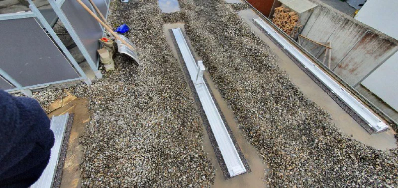 Montageschienen für die Module auf dem Kiesdach des Carports