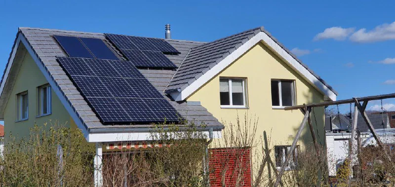 Einfamilienhaus mit fertig montierten Solarmodulen auf dem Hauptdach
